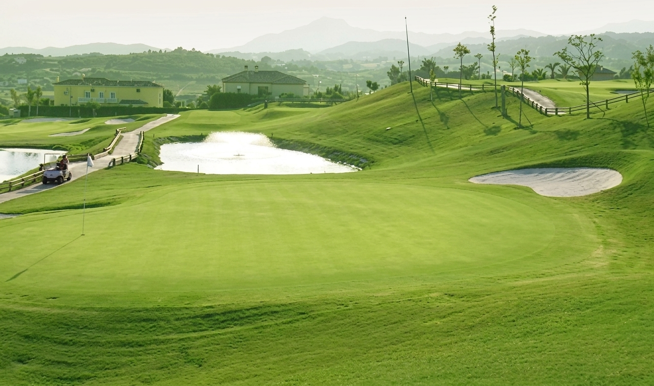 Magna Marbella 9-hole golf course with green fairways and mountain backdrop